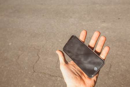 Smartphone with broken screen in hand. cracked screen.の写真素材