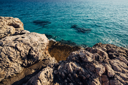 Blue sea water and stone coast Cyprusの写真素材