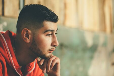 Color close-up portrait of a handsome young guy with fashion haircut thinking.の写真素材