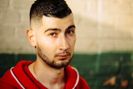 Color close-up portrait of a handsome young guy with fashion haircut looking at the camera.の写真素材