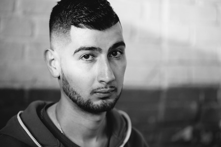 Black and white close-up portrait of a handsome young guy with fashion haircut looking at the camera.の写真素材