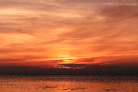Sunset orange sky background at evening with cloudsの写真素材