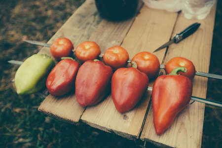 Vegetables on a skewer. Tomatoes red and green bell peppers ready for roasting on a fire.の写真素材