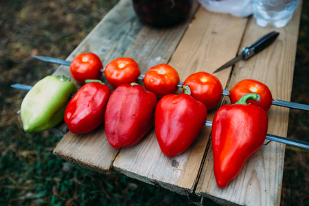 Vegetables on a skewer. Tomatoes red and green bell peppers ready for roasting on a fire.の写真素材