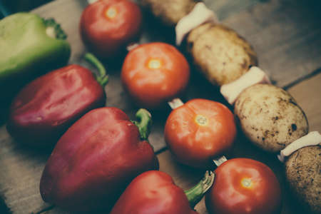 Vegetables on a skewer. Tomatoes. Bell peppers red and green. Potatoes with bacon ready for roasting on a fire.の写真素材