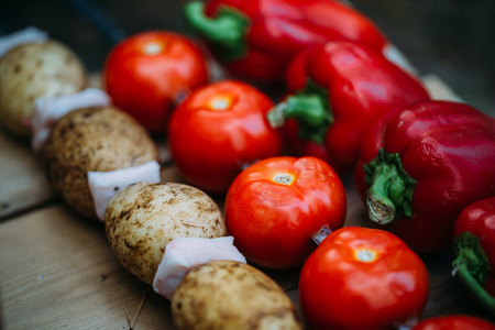 Vegetables on a skewer. Tomatoes. Bell peppers red and green. Potatoes with bacon ready for roasting on a fire.の写真素材
