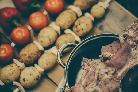 Vegetables on skewers. Meat for barbecue in the pan.の写真素材