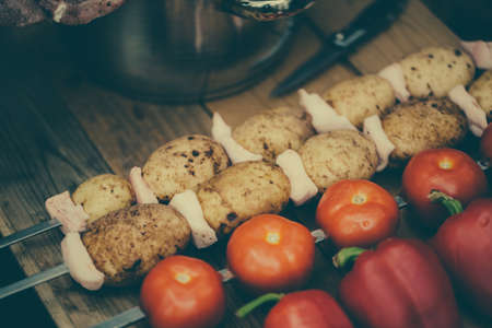 Tomatoes pepper potato with bacon on skewers ready for cooking.の写真素材