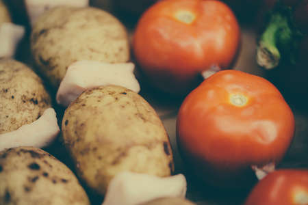 Vegetables on a skewer. Tomatoes. Bell peppers red and green. Potatoes with bacon ready for roasting on a fire.の写真素材