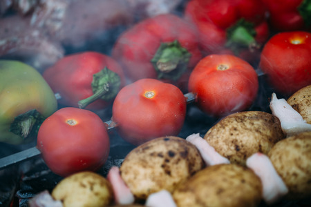Meat and vegetables are roasted on coals. Bell pepper, potato, tomato and meatの写真素材