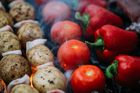 Veggies on barbeque: tomatoes, red bell pepper, potatoes on coals, mangalの写真素材