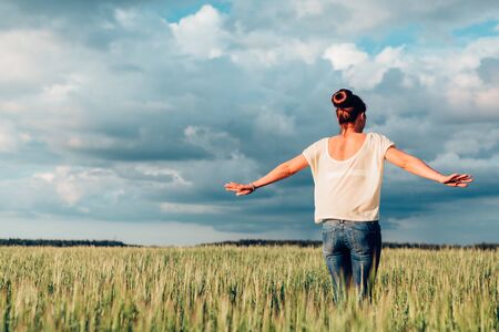 Girl with arms outstretched spinning dance outdoors in a field.の写真素材