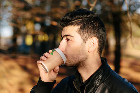 Stylish Armenian man drinking coffee in the park closeup.の写真素材