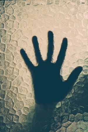 silhouette of the hand behind the glassの写真素材