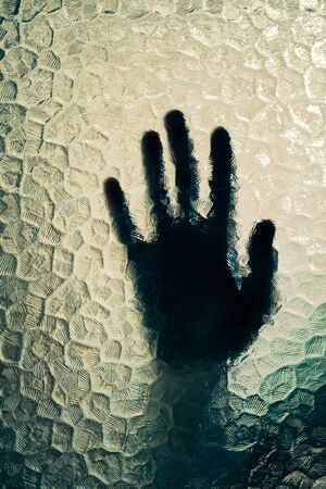 silhouette of the hand behind the glassの写真素材