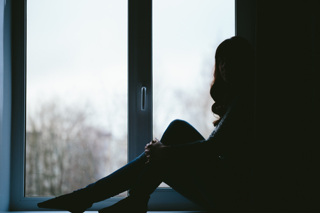 Young woman sexually sits on a window sill. Black and white photo closeup.の写真素材