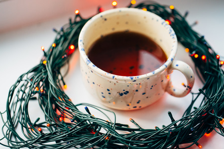 ?up of coffee in the center of the circle of the Christmas lamp garland close upの写真素材