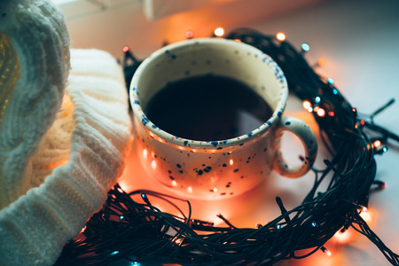 ?up of coffee in the center of the circle of the Christmas lamp garland close up photo with cap.の写真素材