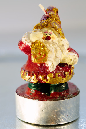 Candle in the shape of santa claus close up photo on a white background.の写真素材