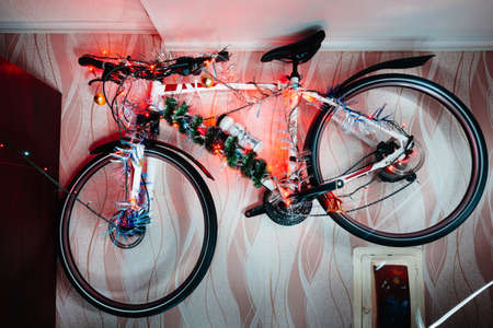 Bicycle on a wall decoration of the christmas lamp garland close up photo.の写真素材