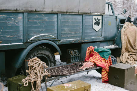 Usual old spring bed covered with blankets against the blue truck.の写真素材