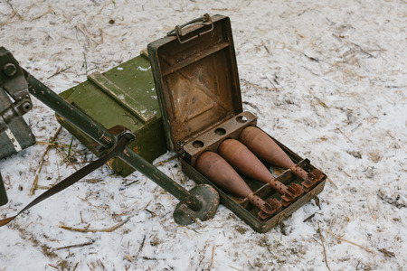 Old bombs in a metal small suitcase on snow.の写真素材