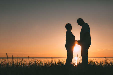 Adult couple silhouettes at sunset. Evening photo.の写真素材