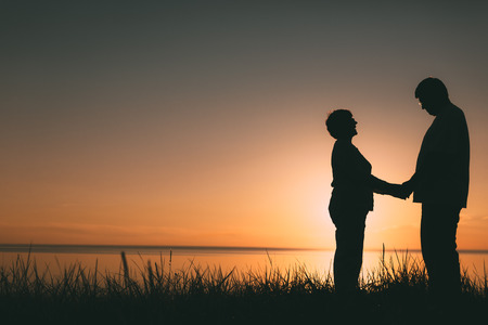 Adult couple silhouettes at sunset. Evening photo.の写真素材