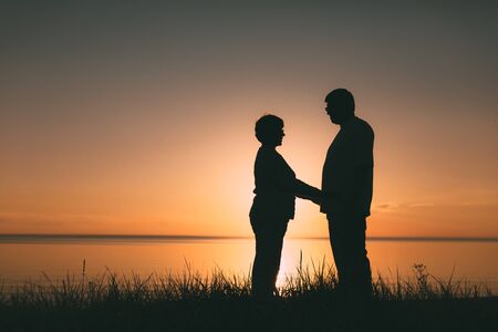Adult couple silhouettes at sunset. Evening photo.の写真素材