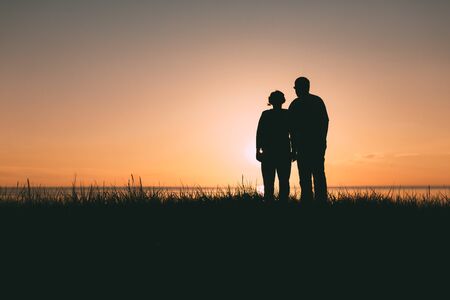 Adult couple silhouettes at sunset. Evening photo.の写真素材