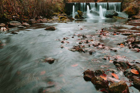 Water flows on stock pipes and follows in the wood. Season photo.の写真素材