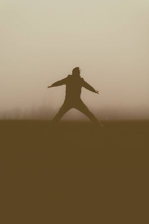 Silhouette of the jumping person in the evening. Outdoors photo.の写真素材