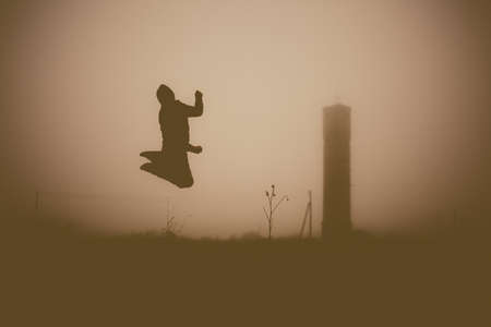 Silhouette of the jumping person in the evening. Outdoors photo.の写真素材
