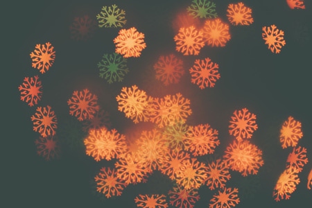 Many orange snowflakes on a dark background. Design wallpaper.の写真素材