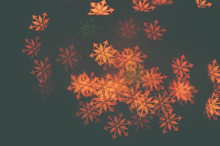 Many orange snowflakes on a dark background. Design wallpaper.の写真素材