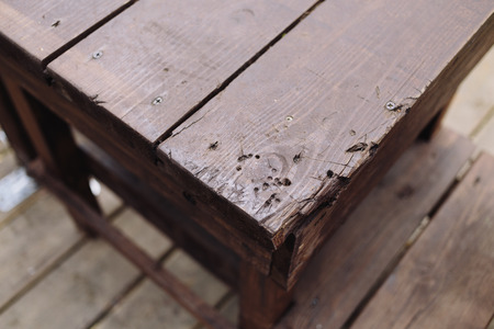 Corner of brown wooden table. Outdoors photo.