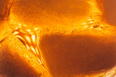 Pieces of ice in a glass with liquid the top view. Close up photo top view.の写真素材