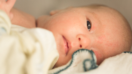 little baby close-up lying down looking around