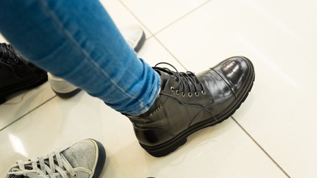 girl measures the new shoes. She stamps her black bootsの写真素材