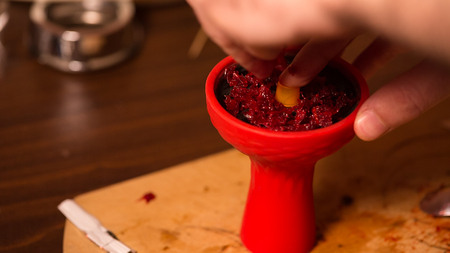 tobacco preparation in the red silicone bowl of shishaの写真素材