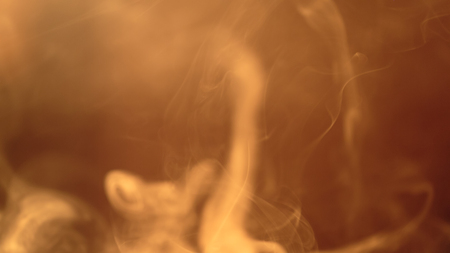 Clubs of white smoke in the rays of the bright warm sun