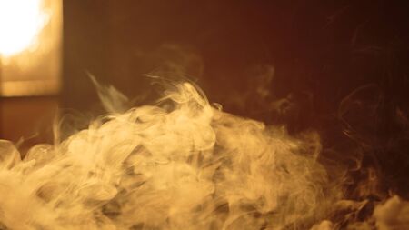 Clubs of white smoke in the rays of the bright warm sunの写真素材