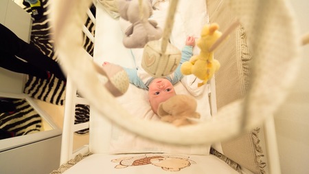 Baby lying in his cot and playing with Crib Mobiles. top viewの写真素材