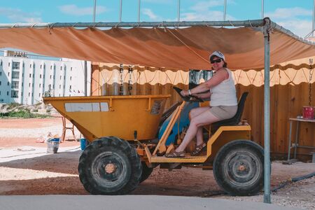Woman middle-aged tourist photographed the tractor on vacation
