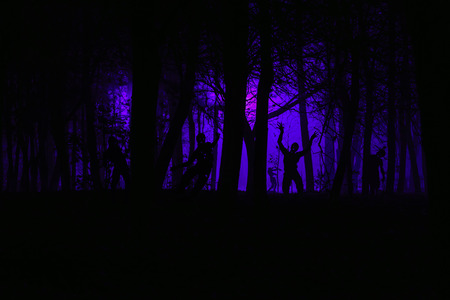 crowd of hungry zombies in the woods. Silhouettes of scary zombies walking in the forest at nightの写真素材