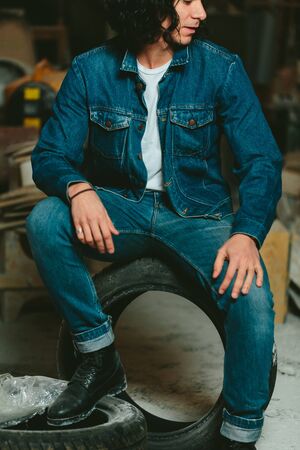 Young handsome man with long hair brunette in a denim jacketの写真素材