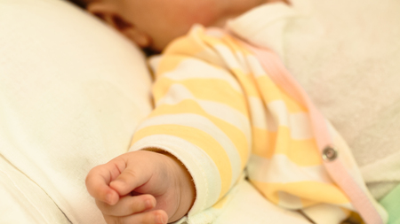 Little baby is resting in his crib close-upの写真素材