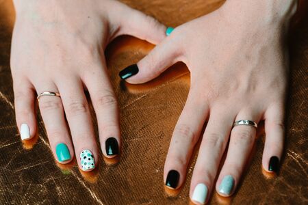 Female hand with trendy manicure. Nail design on a gold background closeupの写真素材