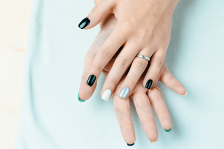 Female hand with trendy manicure. Nail design on a white background closeupの写真素材