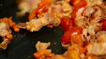 tomatoes bacon onion carrots in a pan closeupの写真素材